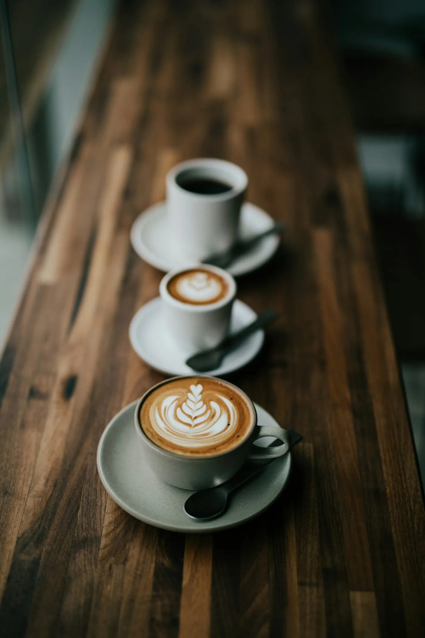 Ceramic cups of coffee arranged on a wooden table